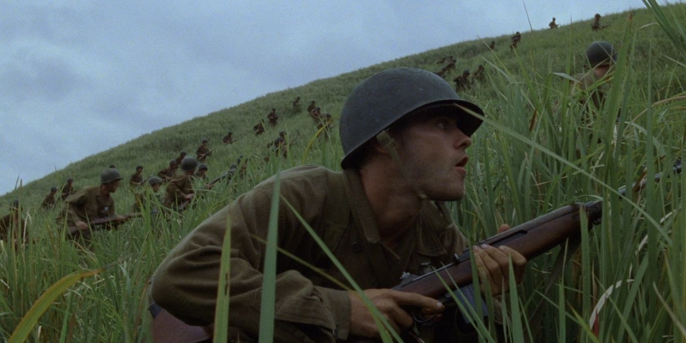 A soldier crouching in the grass in The Thin Red Line