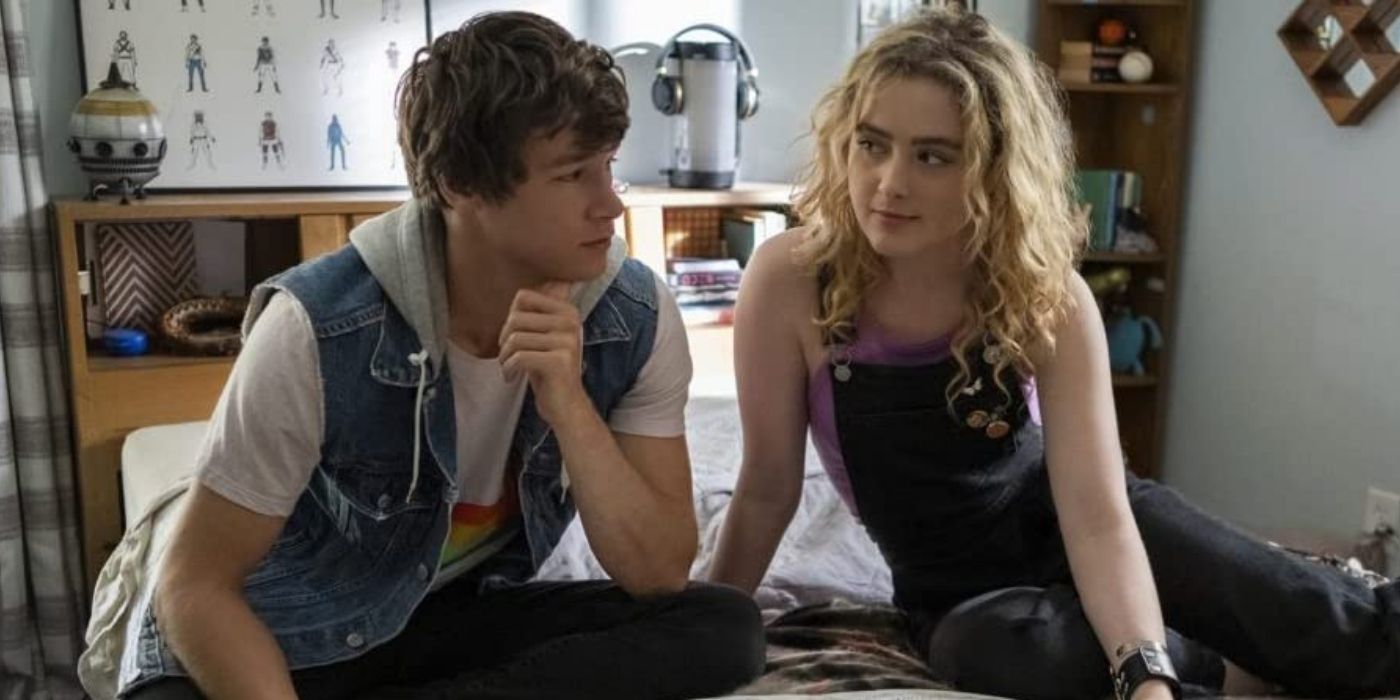 Kyle Allen as Mark and Kathryn Newton as Margaret sitting on a bed in The Map of Tiny Perfect Things