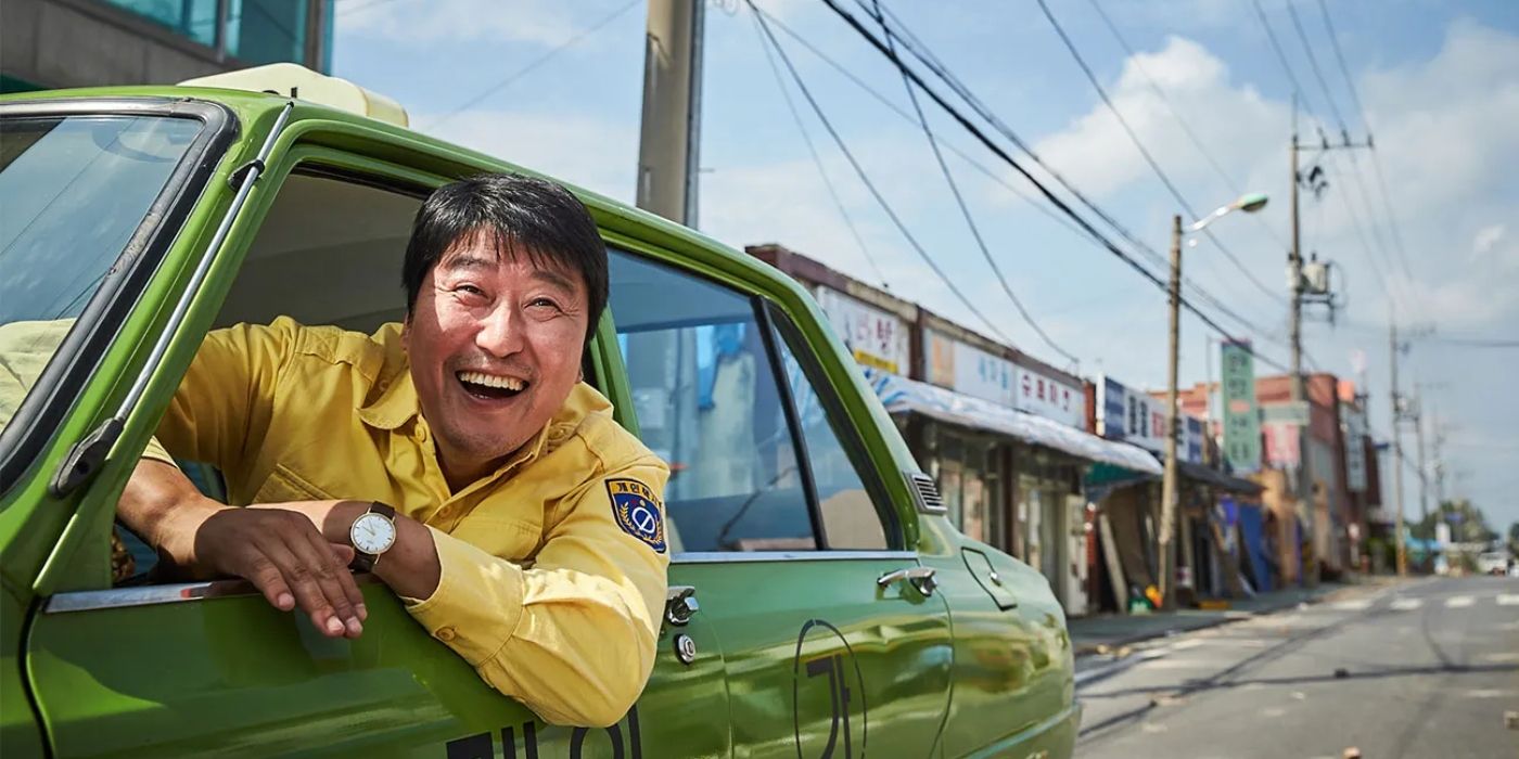 Song Kang-ho as Kimg Man-seob, smiling as he sticks his head out of a taxi