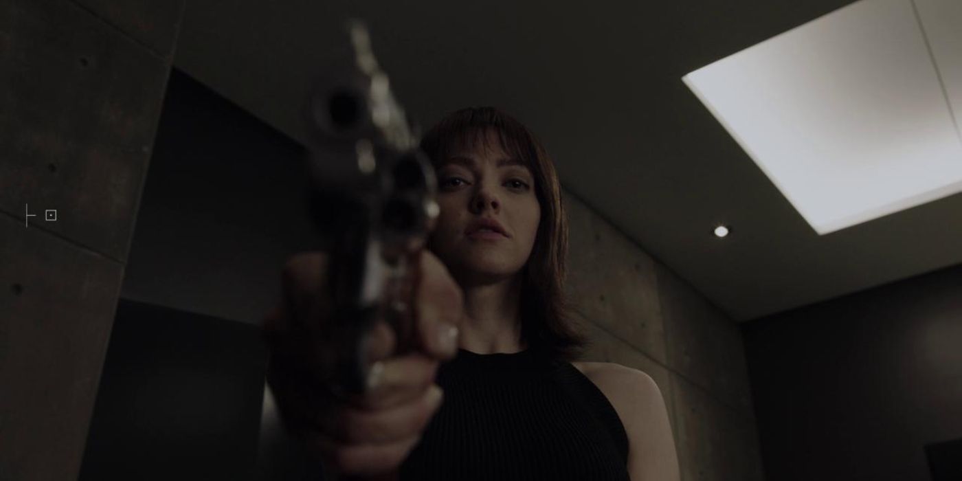 Amanda Seyfried as Anon pointing a gun at the camera in in Anon (2018)