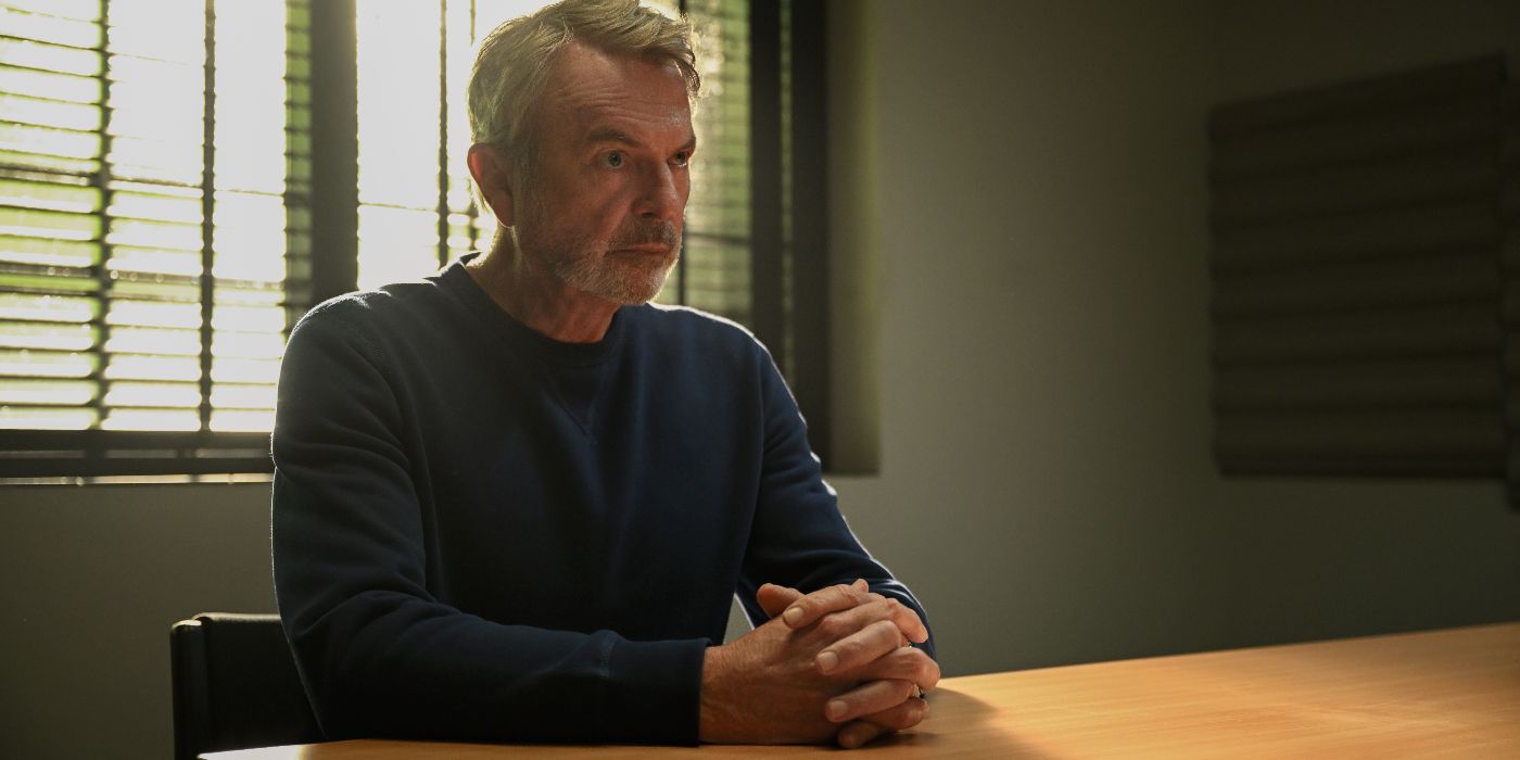 Apples Never Fall actor Sam Neill as Stan Delaney sitting at a desk looking at someone off-screen