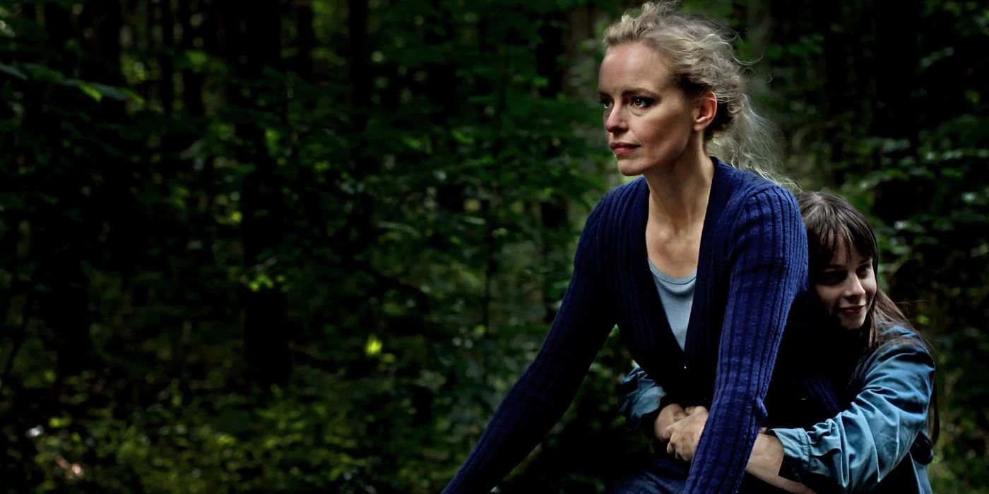 Nina Hoss riding a bike through a forest in Barbara (2012)