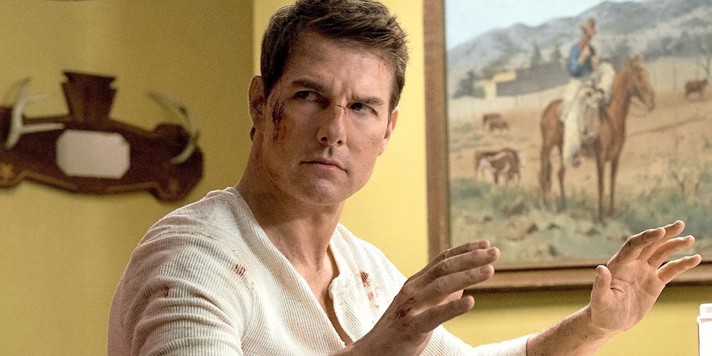 Tom Cruise as Jack Reacher wearing a white shirt with blood on it and on his cheek in Jack Reacher: Never Go Back