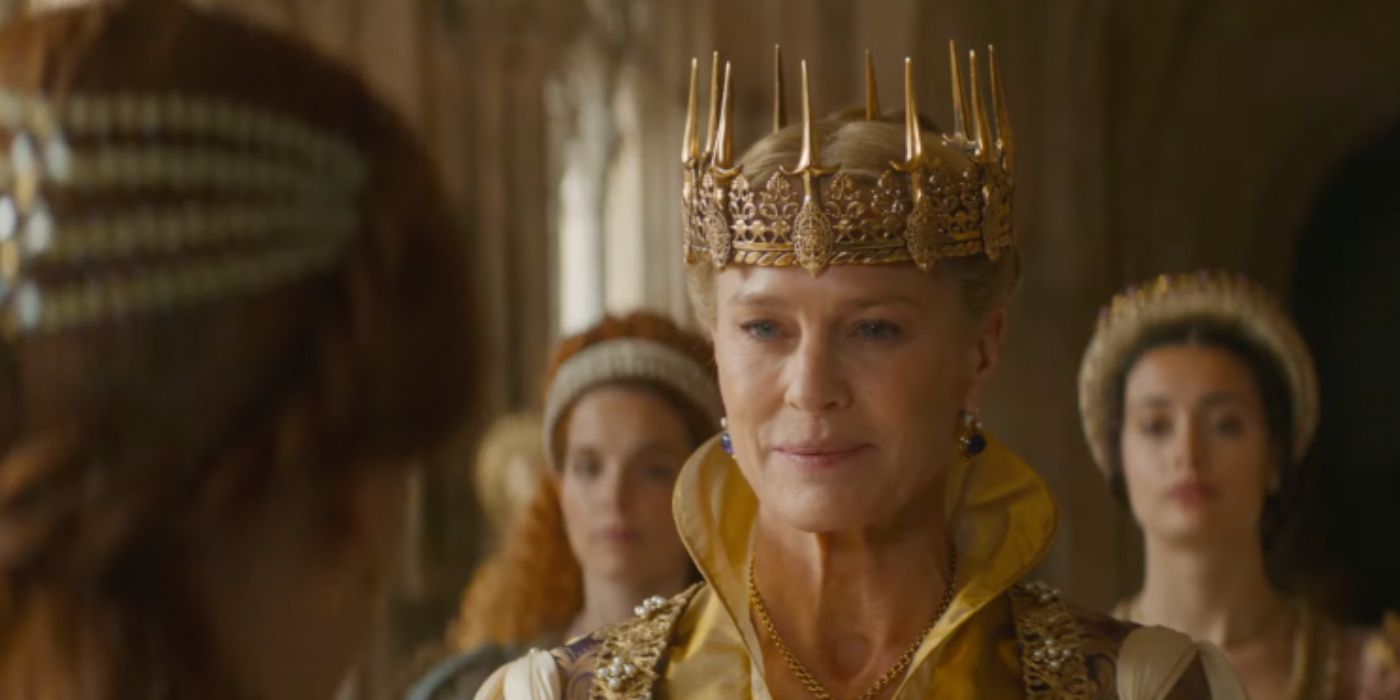 Robin Wright as Queen Isabelle wearing a golden dress and crown, with two women behind her out of focus in Damsel