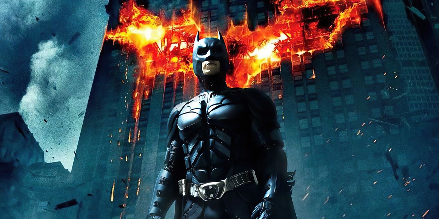 Christian Bale as Batman standing in front of a flaming bat symbol in The Dark Knight