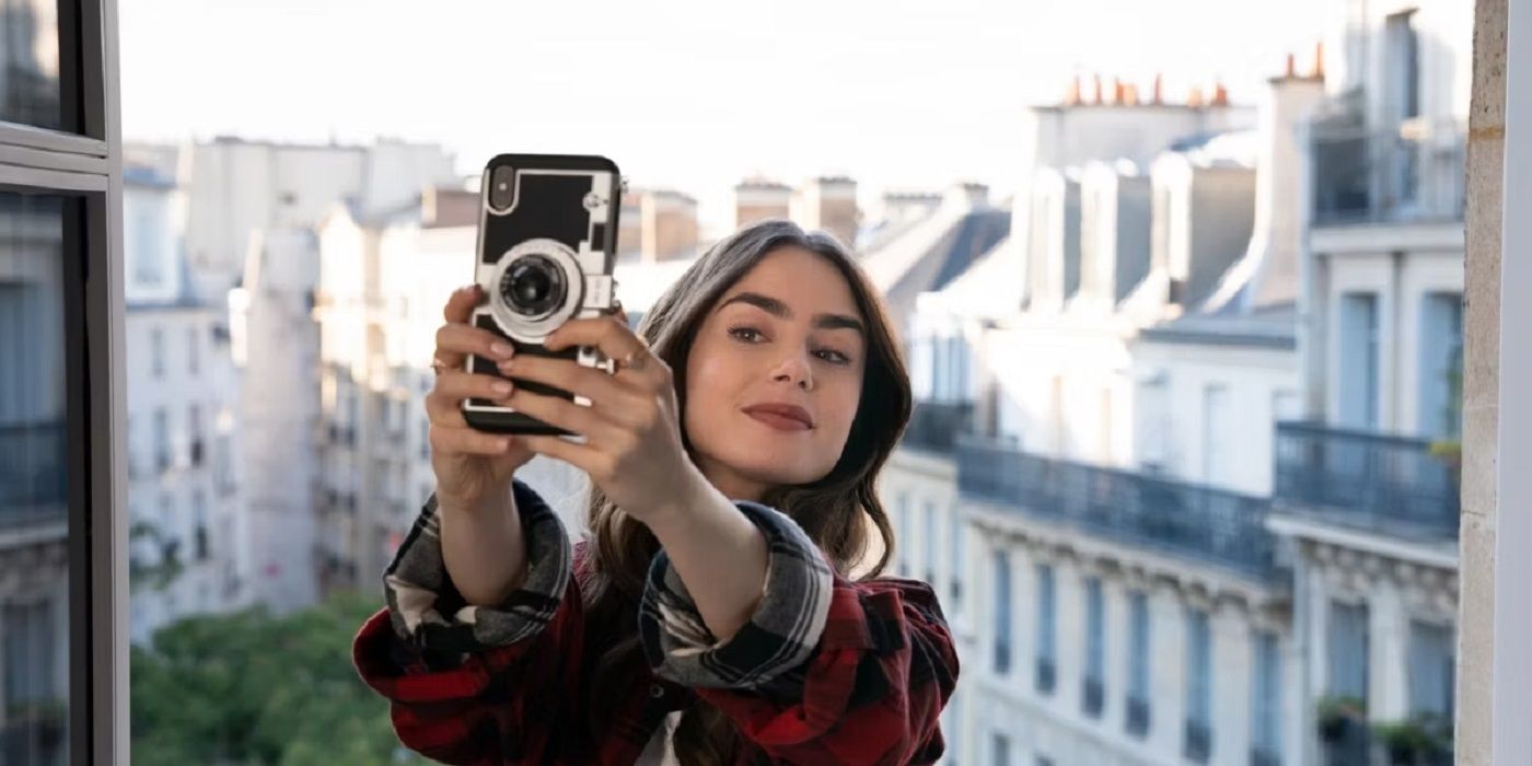 Emily in Paris star Lily Collins holding a mobile phone taking a selfie