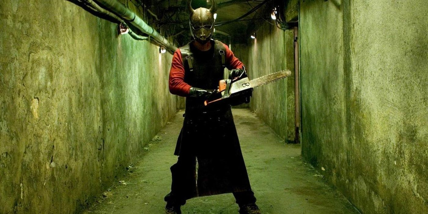 A person with a chainsaw in their hands and a creepy mask in the film hostel