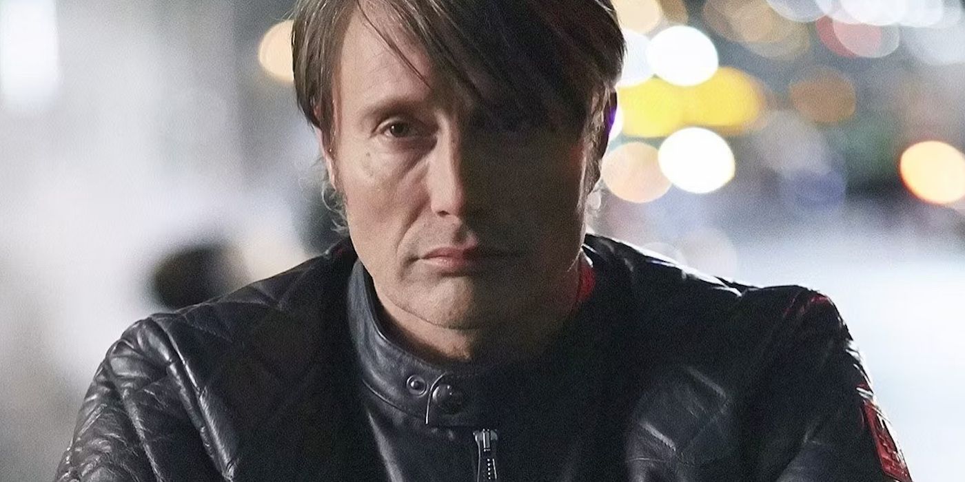 Mads Mikkelsen in Hannibal staring at the camera dressed in a leather jacket.