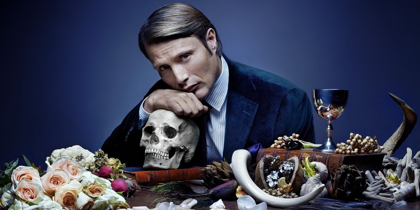 Mads Mikkelsen leaning on a skull in Hannibal.