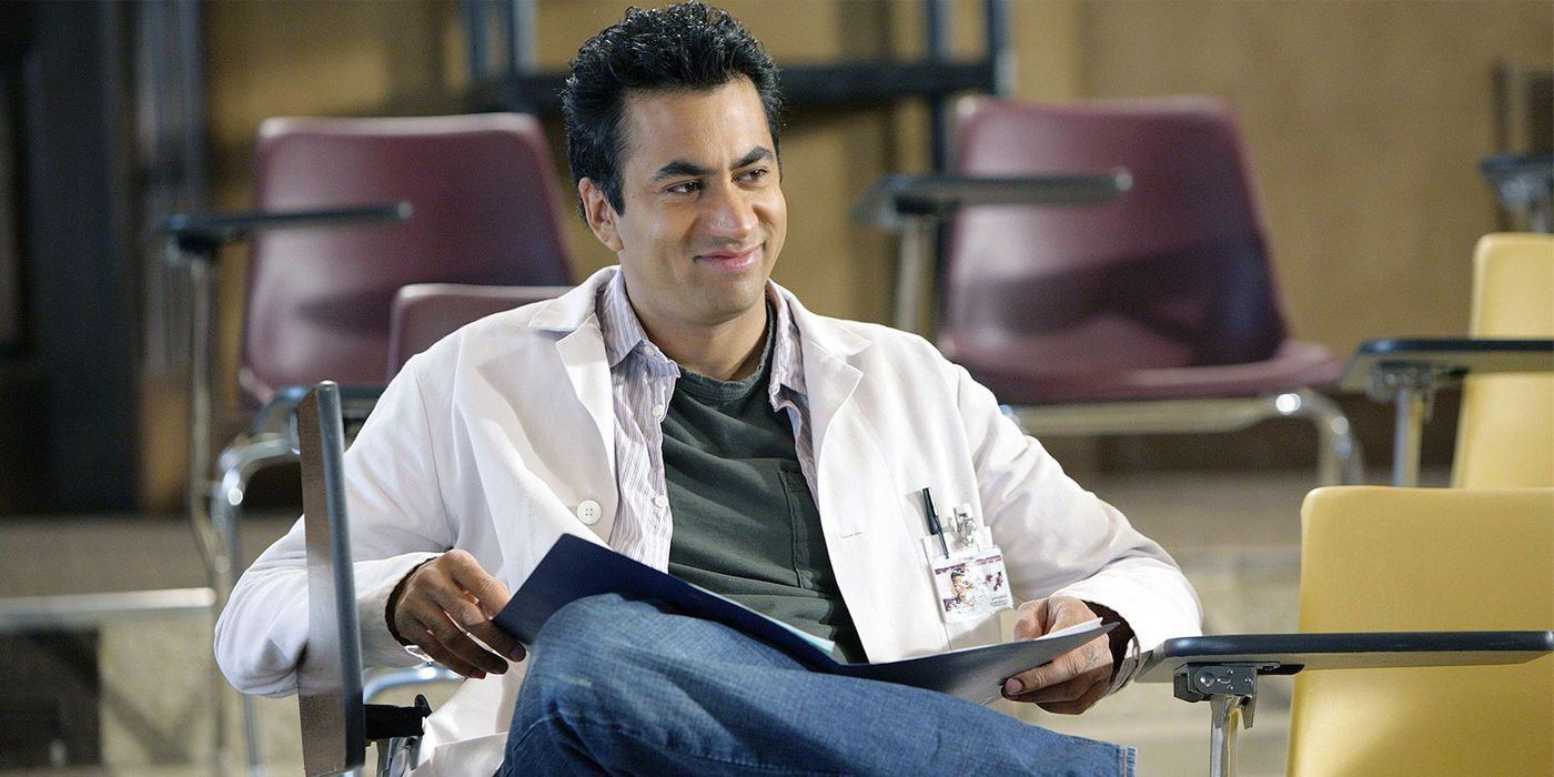 Kal Penn as Dr. Lawrence Kutner smiling and reading notes in House, M.D.