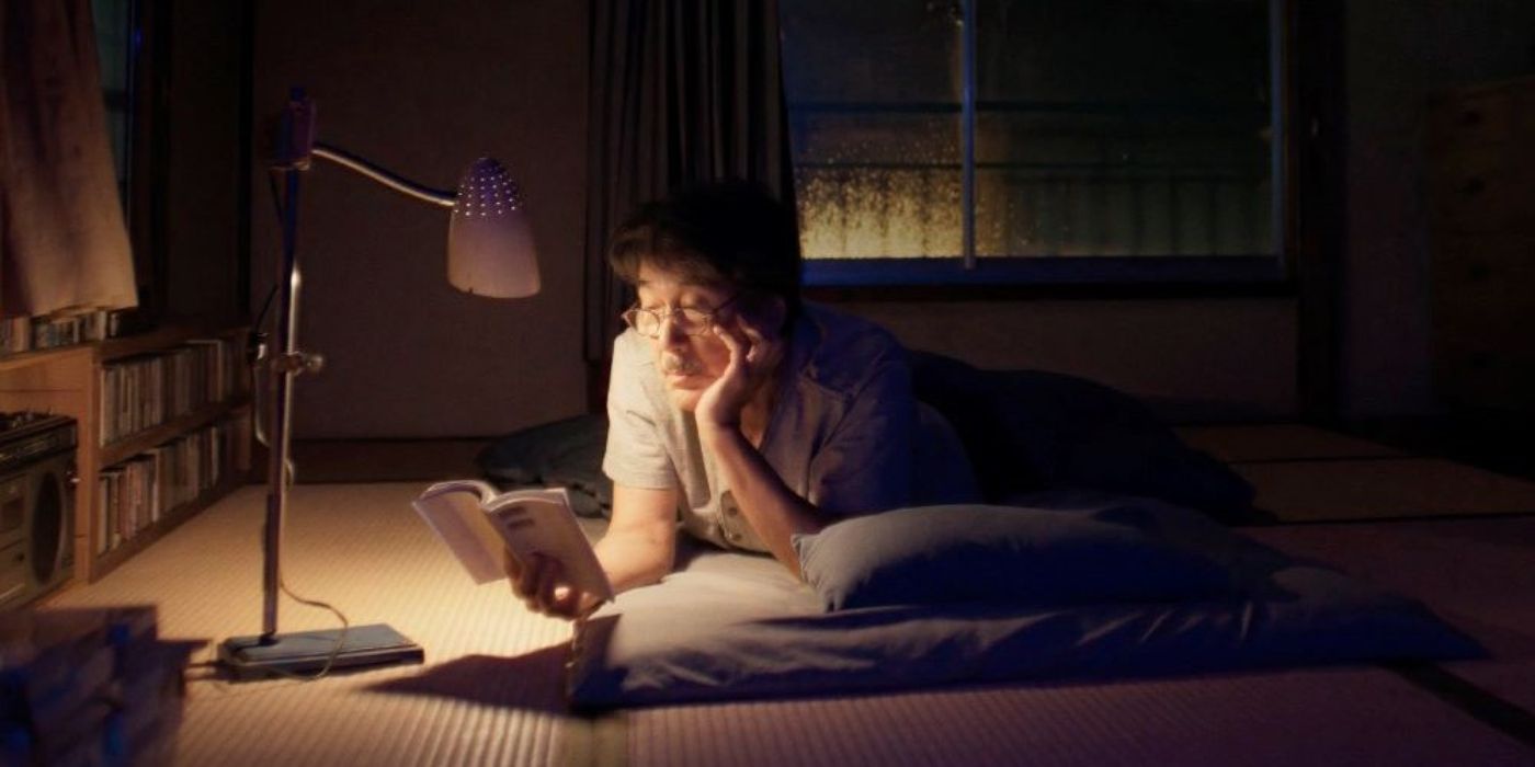 Koji Yakusho lê à noite no chão em Perfect Days