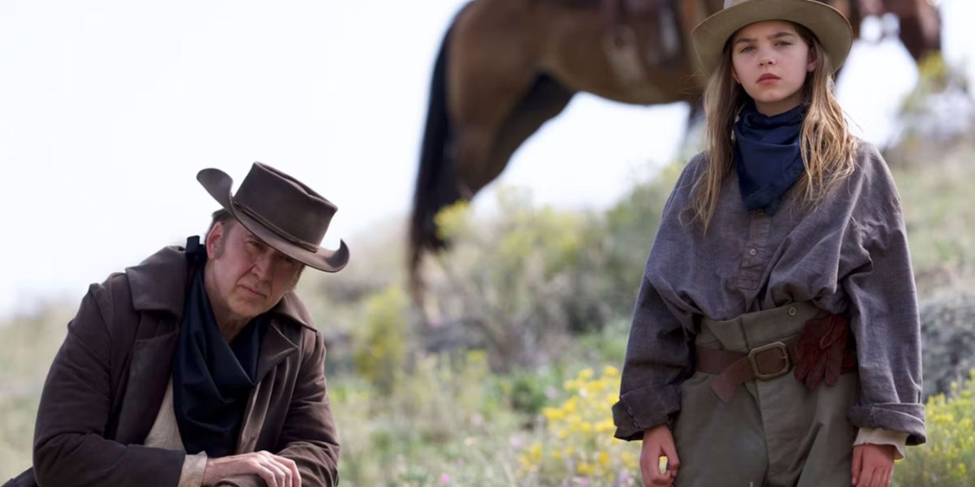 Nicolas Cage as Colton Briggs and Ryan Keira Armstrong as Brooke Briggs sitting in a field in The Old Way