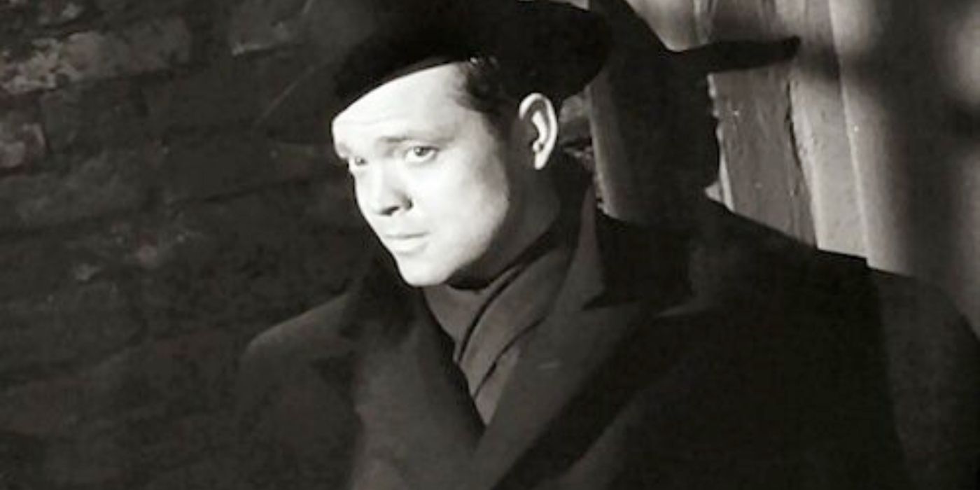 Orson Welles as Harry Lime wearing a dark long coat, scarf, and black hat in The Third Man noir Carol Reed
