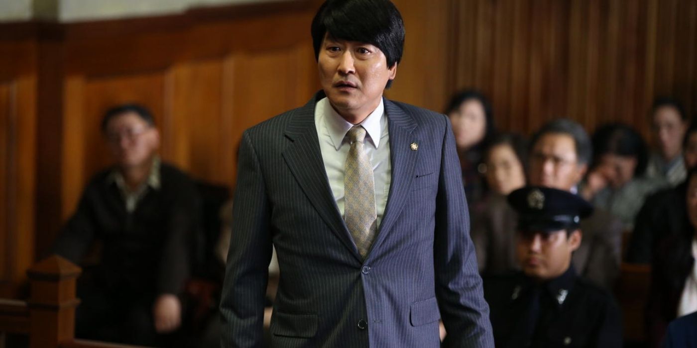 Song Kang-ho as Song Woo-seok, wearing a pinstripe suit in a courtroom