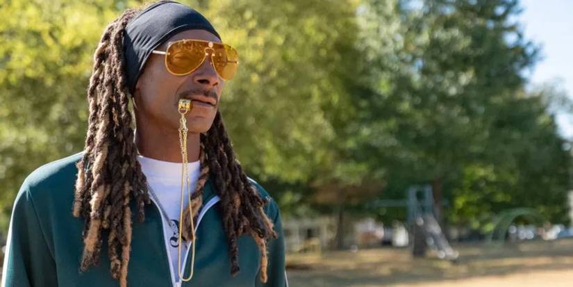Snoop Dogg as Jaycen wearing a green jacket with a gold whistle at practice in The Underdoggs