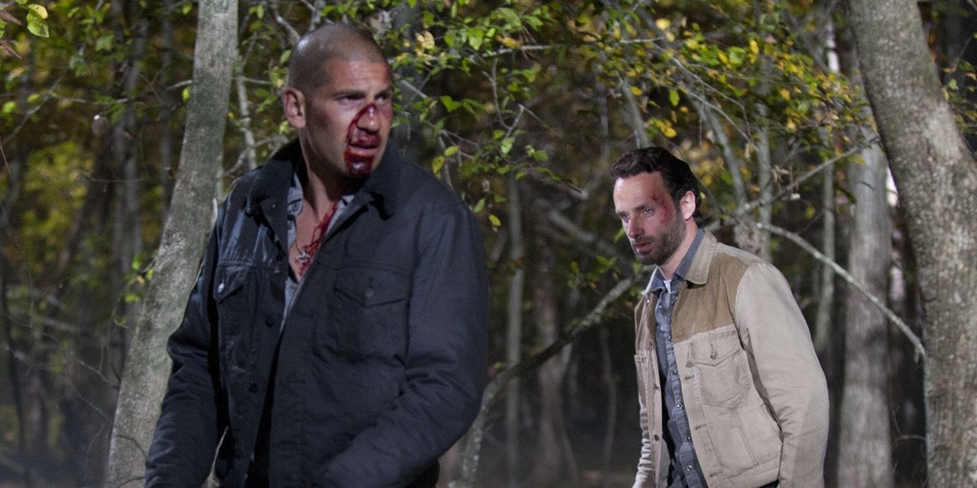 Shane and Rick walking in the forest in The Walking Dead, Shane bloody and Rick looking at him from behind.
