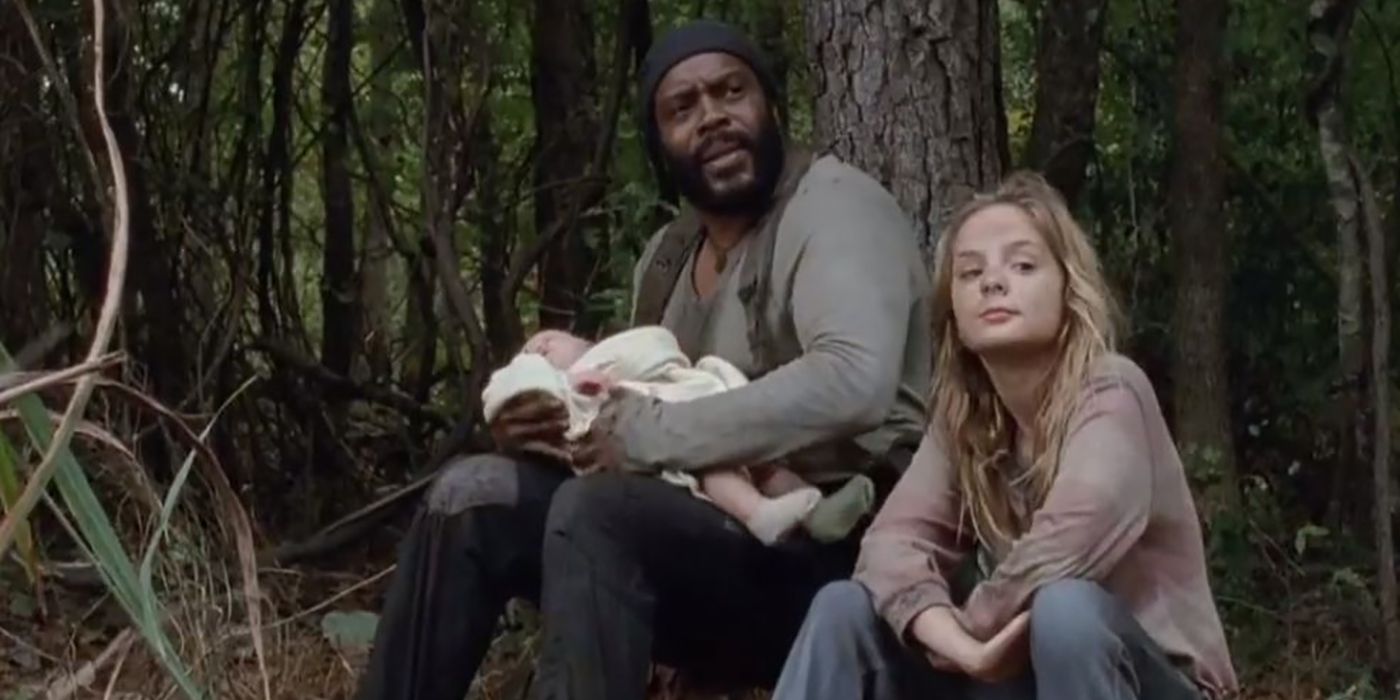 Tyreese holding baby Judith, Lizzy sitting beside him in a scene from The Walking Dead.