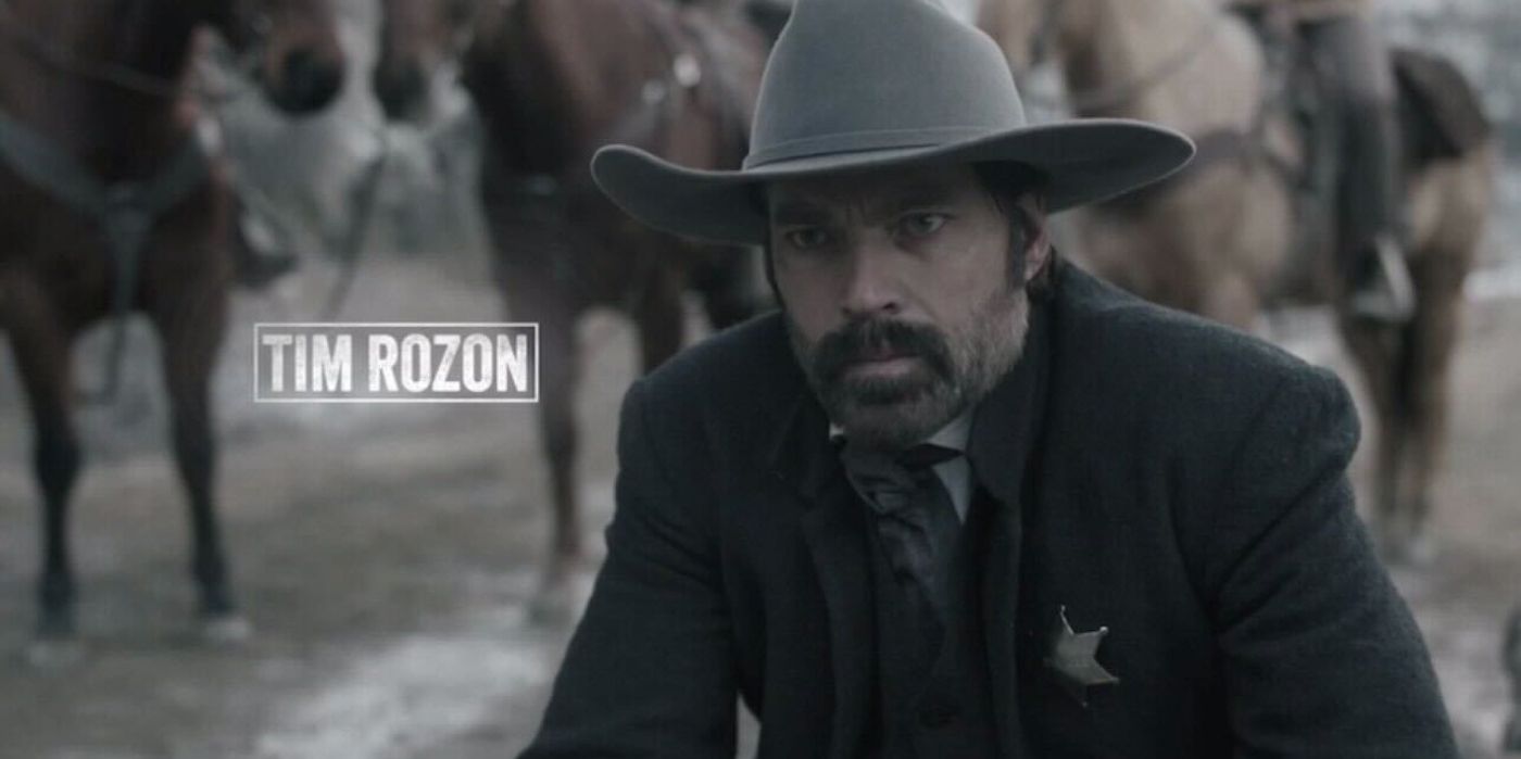 Tim Rozon as Mason wearing a cowboy hat and sheriffs badge in Calamity Jane