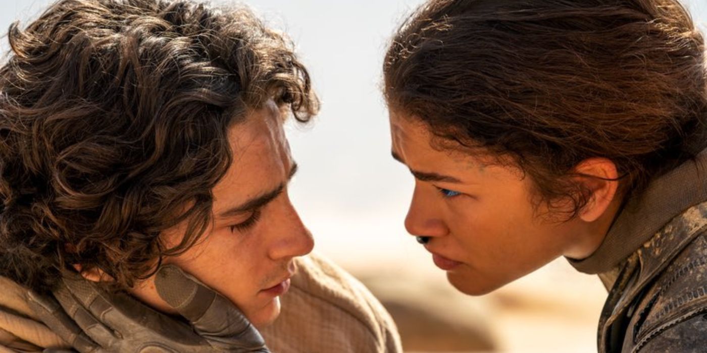Timothée Chalamet as Paul Atreides and Zendaya as Chani holding his face in the desert in Dune: Part Two