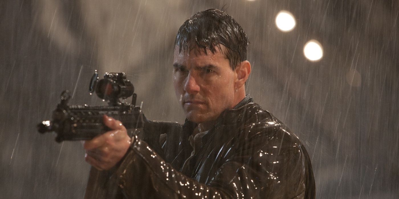 Tom Cruise as Jack Reacher holding a large assault rifle pointing it at someone in the rain in Jack Reacher