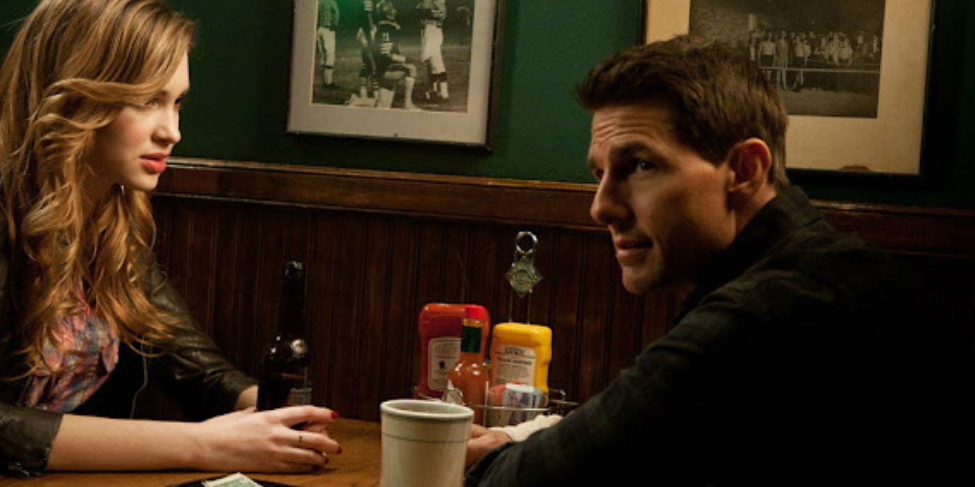 Tom Cruise as Jack Reacher wearing a flannel shirt sitting at a table in a diner talking to a woman in Jack Reacher