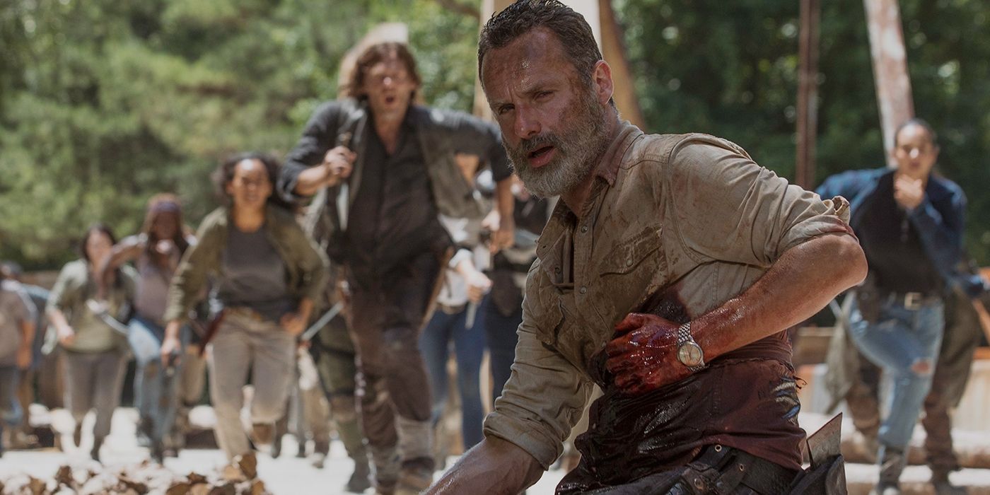 Andrew Lincoln as Rick clutching his bleeding chest, Daryl leading others running towards him on The Walking Dead.
