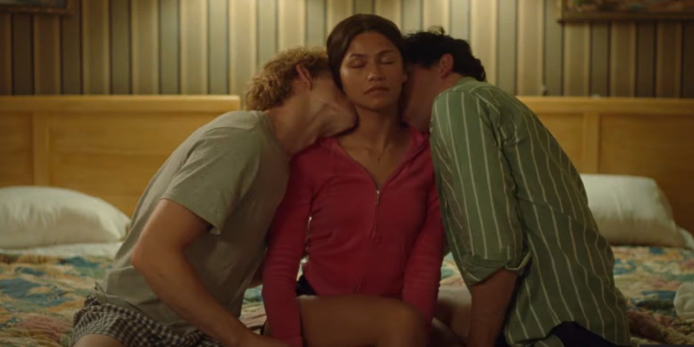 Zendaya as Tashi being kissed by Mike Faist as Art and Josh O'Connor as Patrick on a bed in Challengers