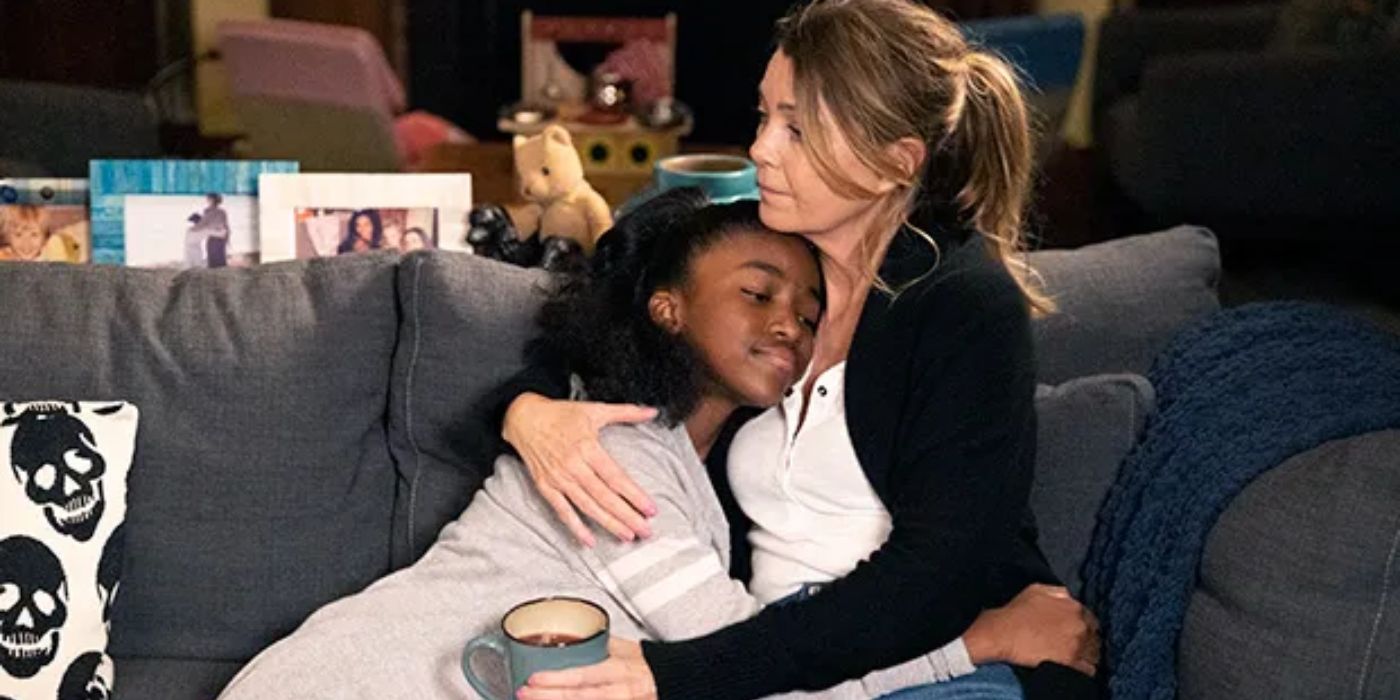 Aniela Gumbs as Zola and Ellen Pompeo as Meredith hugging each other on a couch in Grey's Anatomy