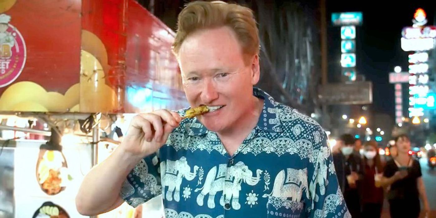 Conan O'Brien eating food on a stick from a street vendor in Conan O'Brien Must Go