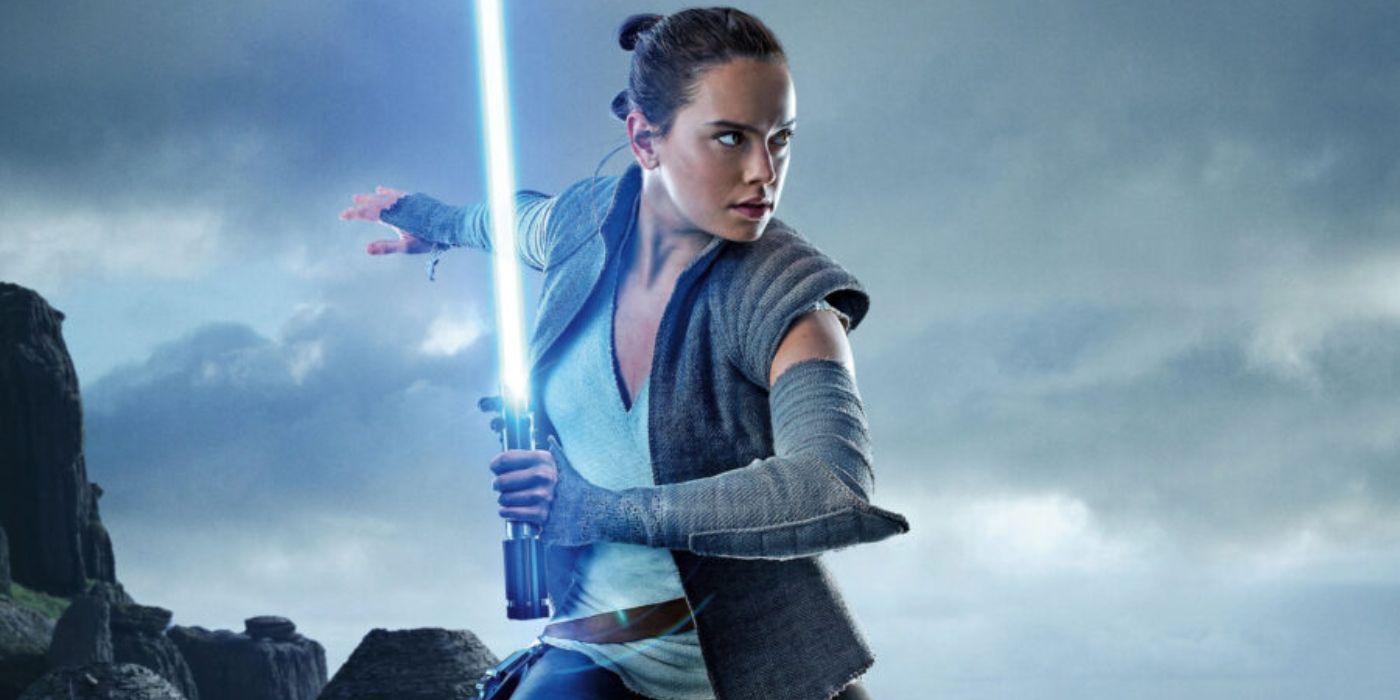 Daisy Ridley with a lightsaber, wearing grey clothes as Rey in Star Wars