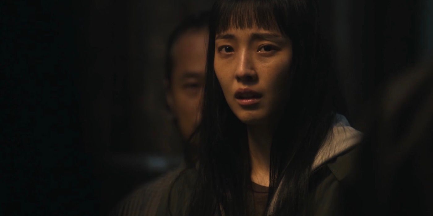 Jung Soo In wearing a hoodie surround by people with a worried look on her face in Parasyte: The Grey