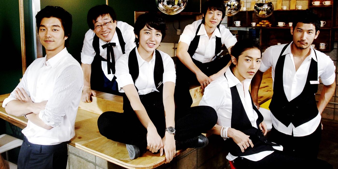 The Cast of Coffee Prince, in uniform,  smiling in the coffee shop of the same name 