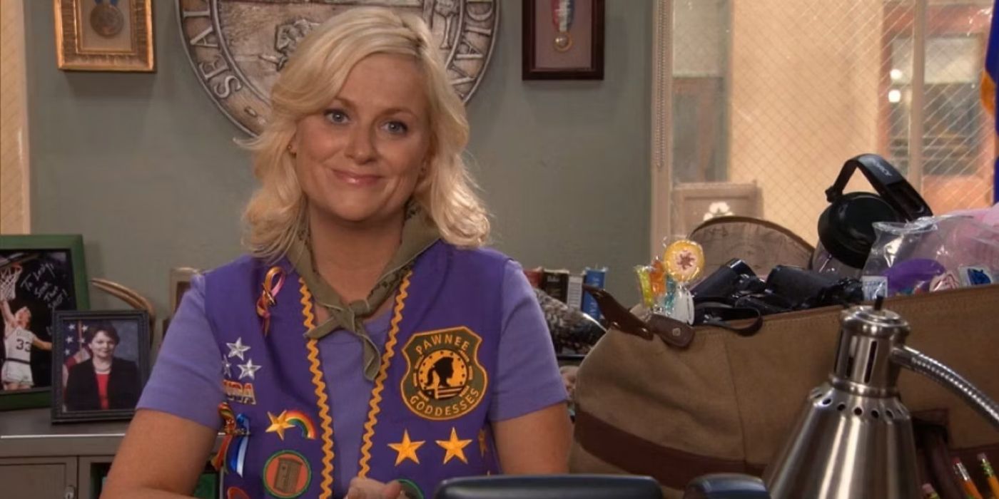 Leslie sitting at her desk in a Pawnee Godesses vest.