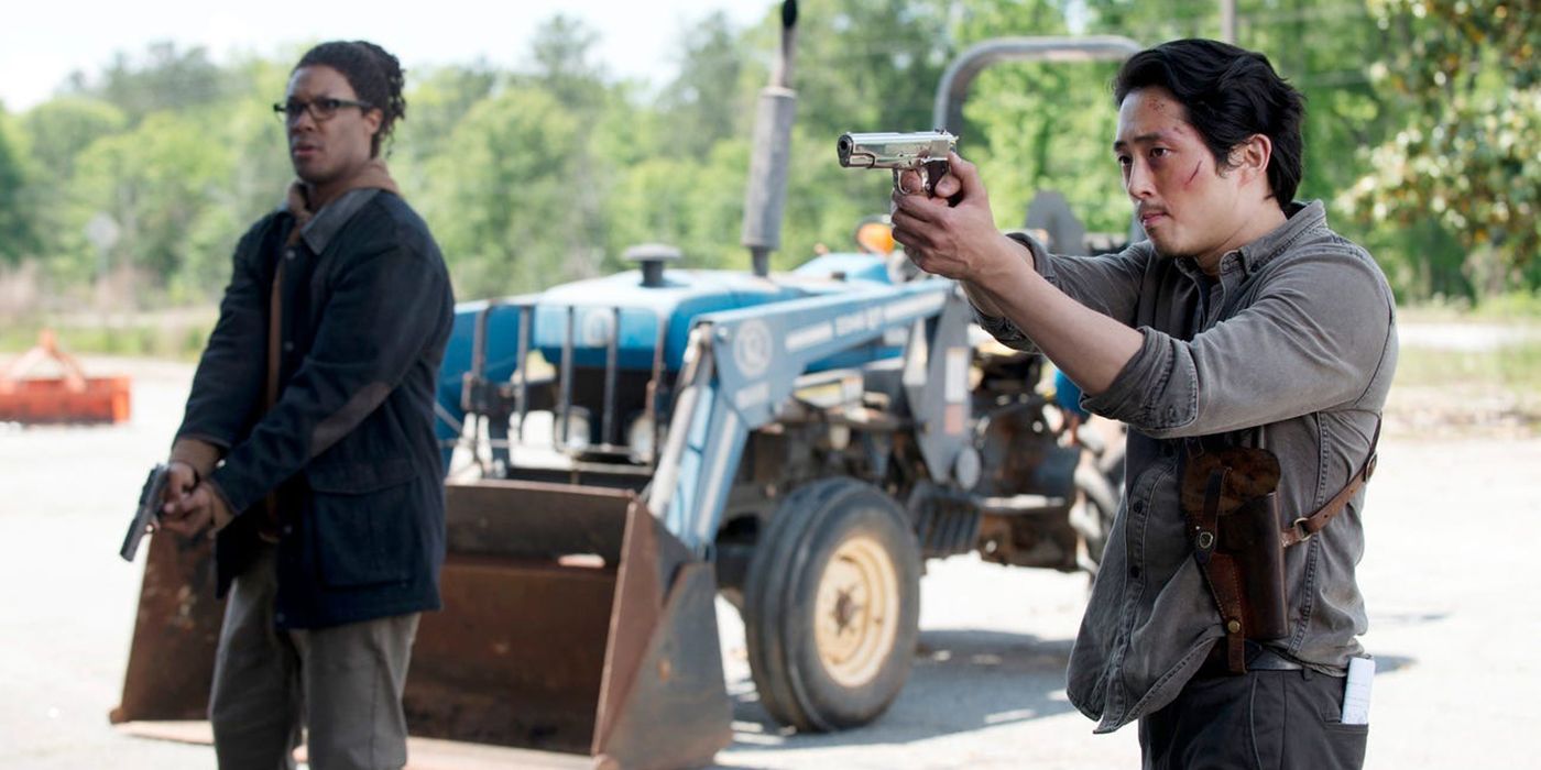 Heath standing beside Glenn, both holding guns and pointing them at someone off-screen on The Walking Dead.