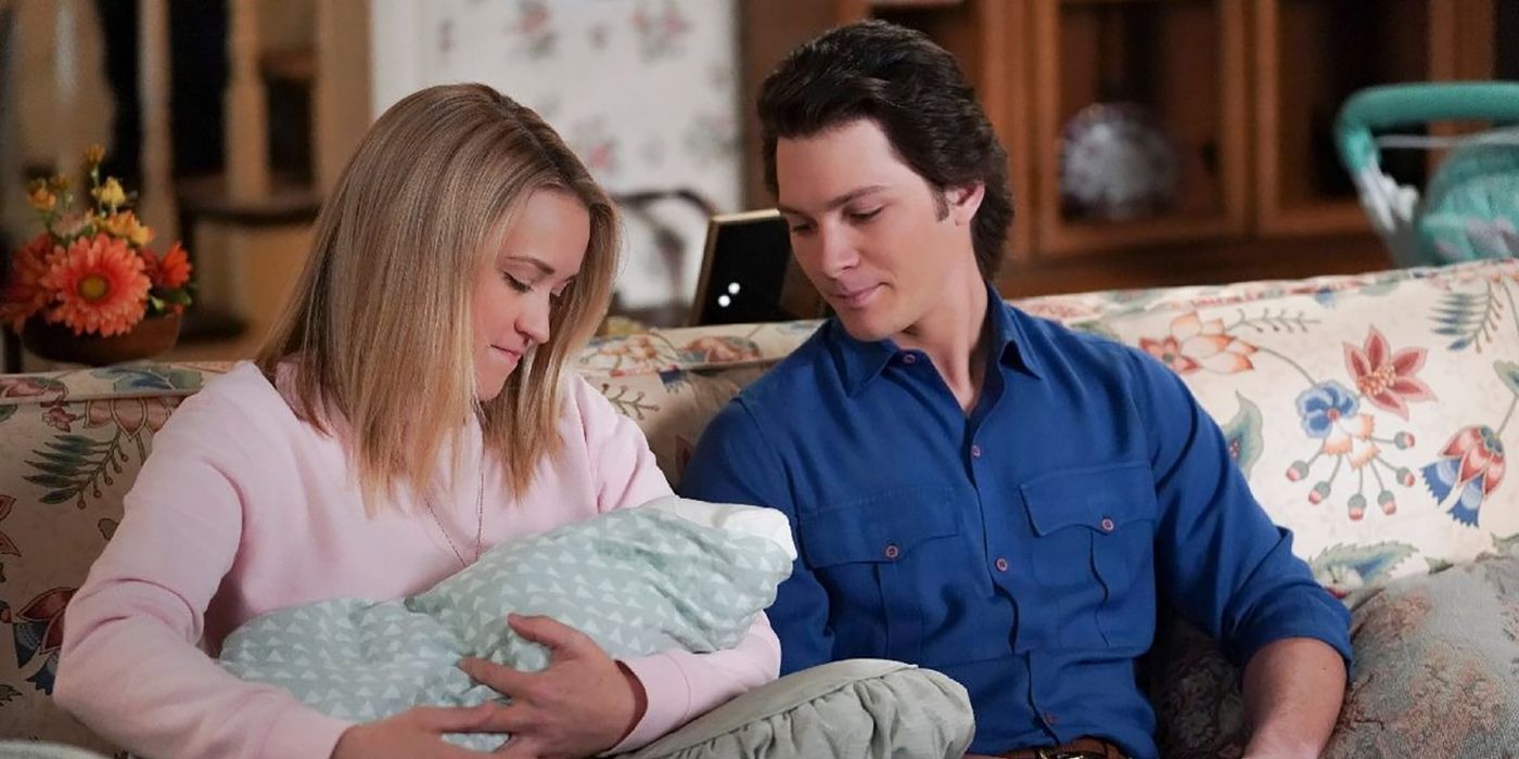 Mandy holding the baby, Georgie looking on both sitting on the couch on Young Sheldon