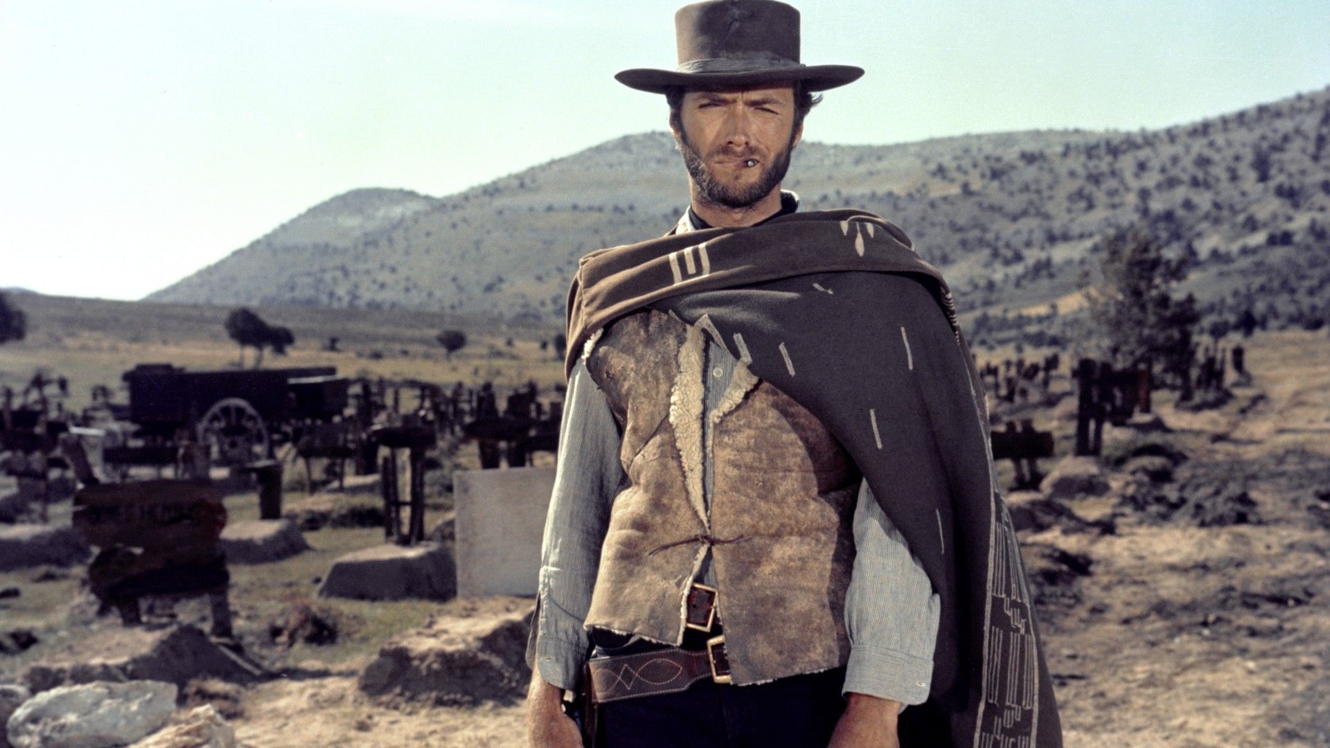 Clint Eastwood with a cigarette in his mouth standing in a desert in The good, the Bad and the Ugly