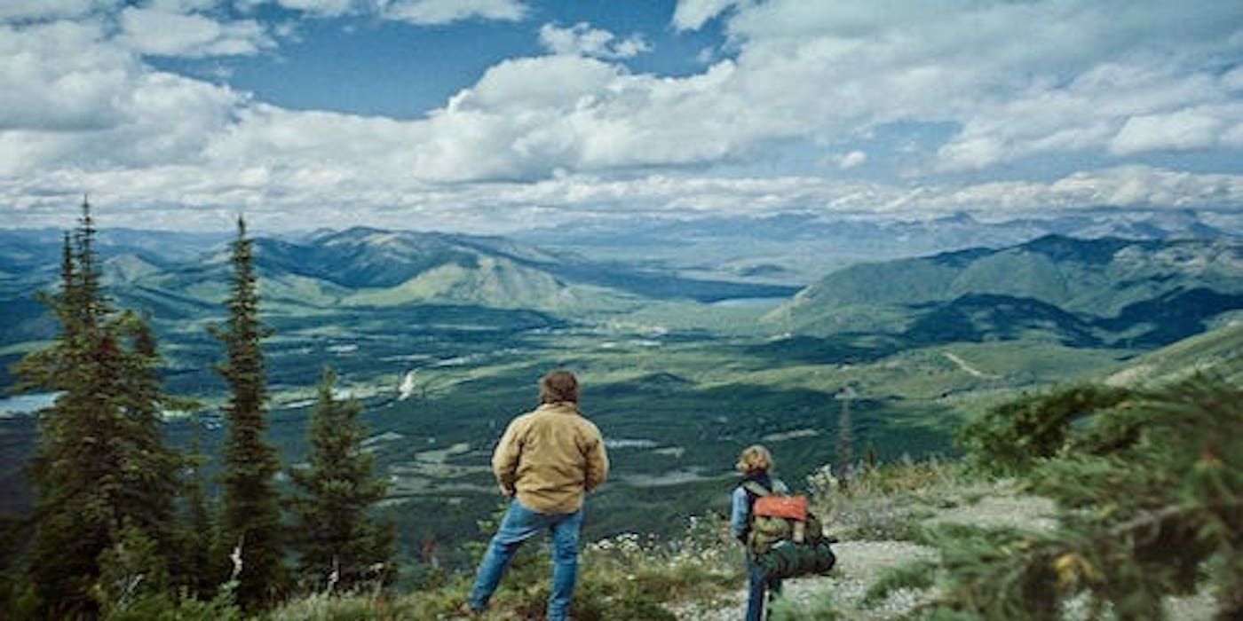 Two people stand atop a mountain in Cowboys