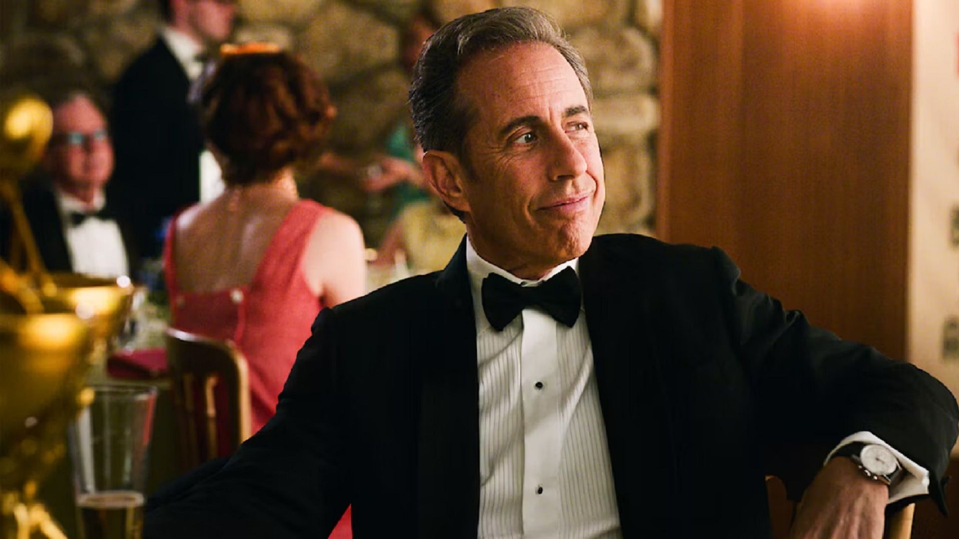 Jerry Seinfeld sitting at a table in tuxedo and bow tie