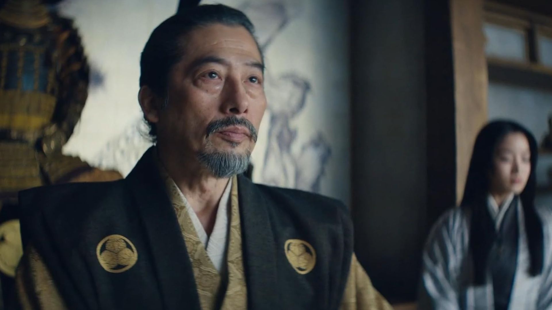 Hiroyuki Sanada as Lord Yoshii Toranag wearing black and gold robes looking off-screen in Shogun