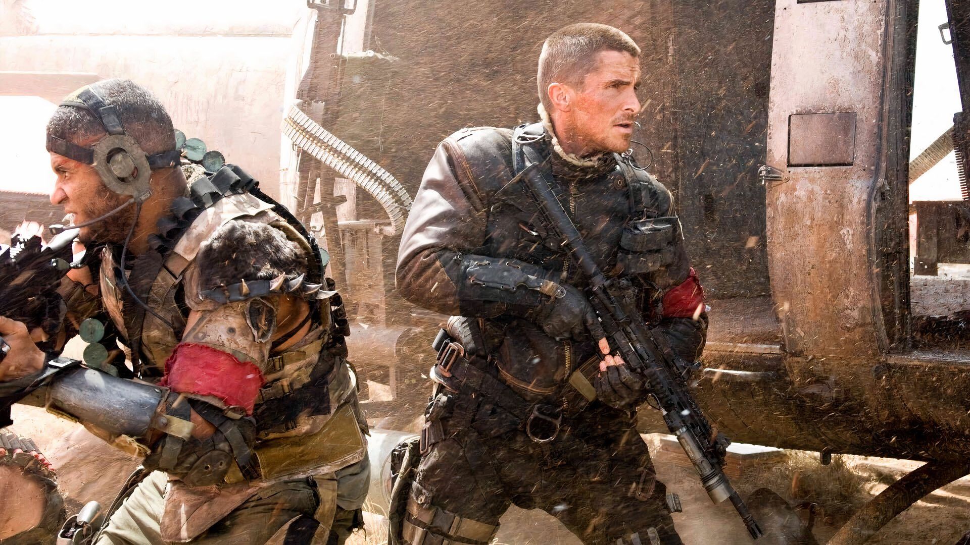 Christian Bale holding as assault rifle next to a helicopter in Terminator Salvation
