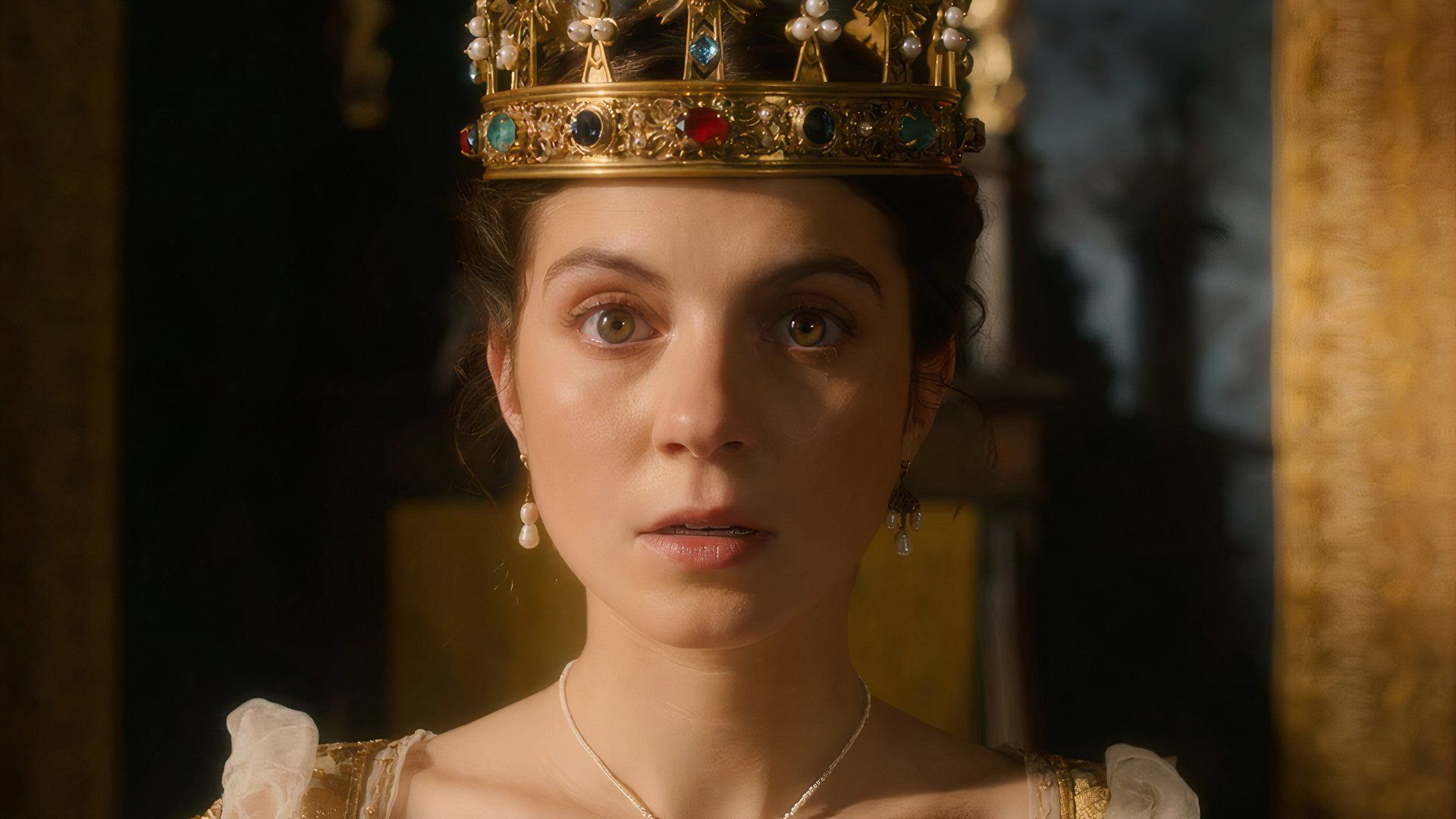 Emily Bader wearing a crown with a shocked look on her face in My Lady Jane