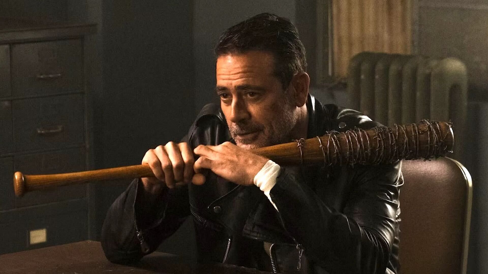 Jeffrey Dean Morgan as Negan holding Lucille at a table