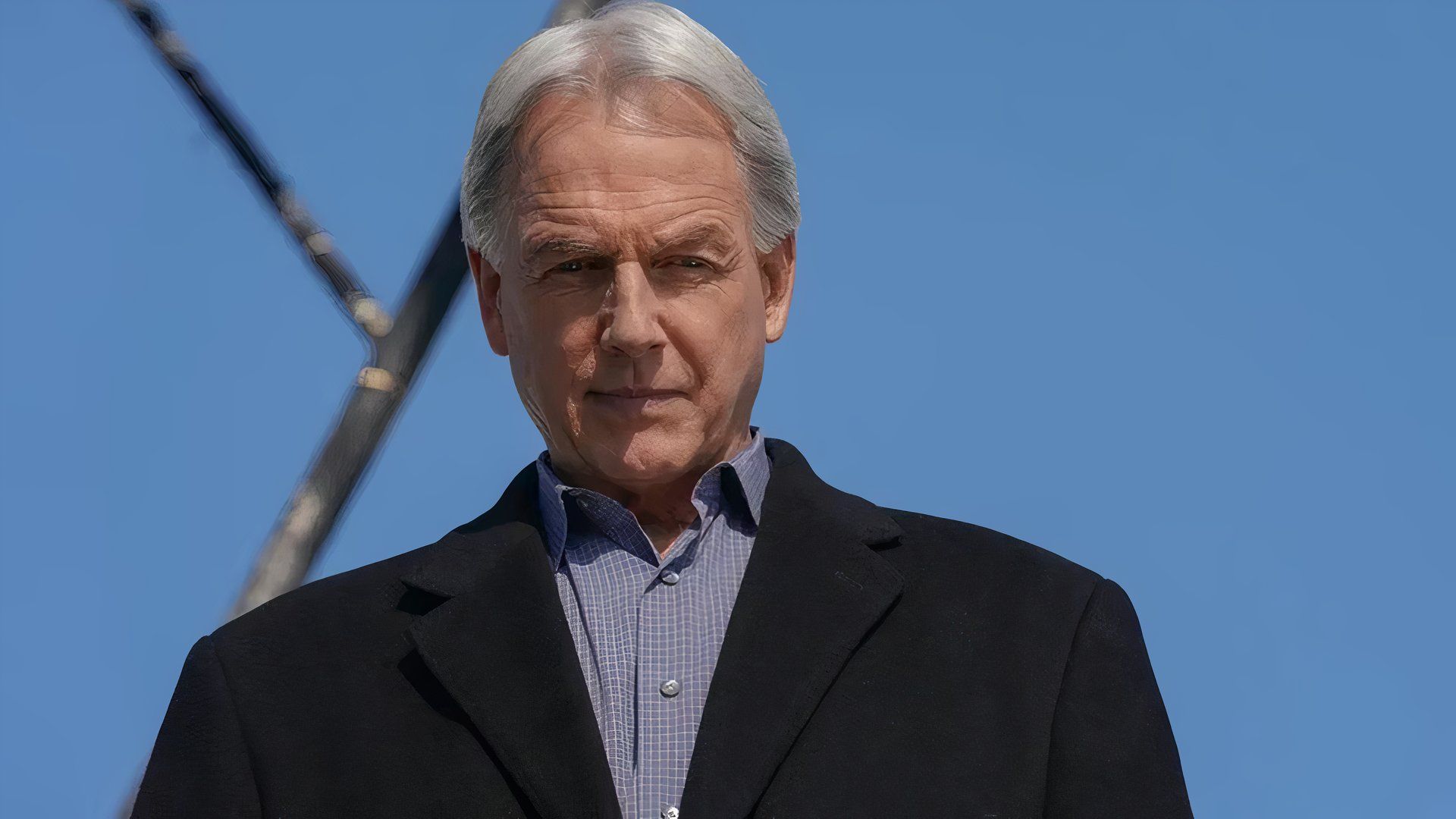 Mark Harmon as Leroy Jethro Gibbs wearing a suit jacket looking down at something off-screen in NCIS (1)