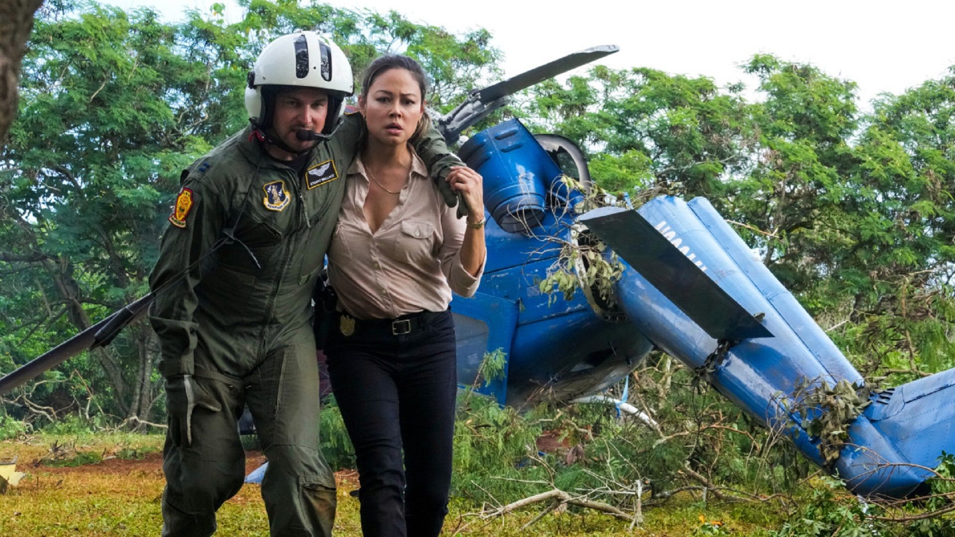 Vanessa Lachey walking with a crashed helicopter pilot in NCIS Hawai'i