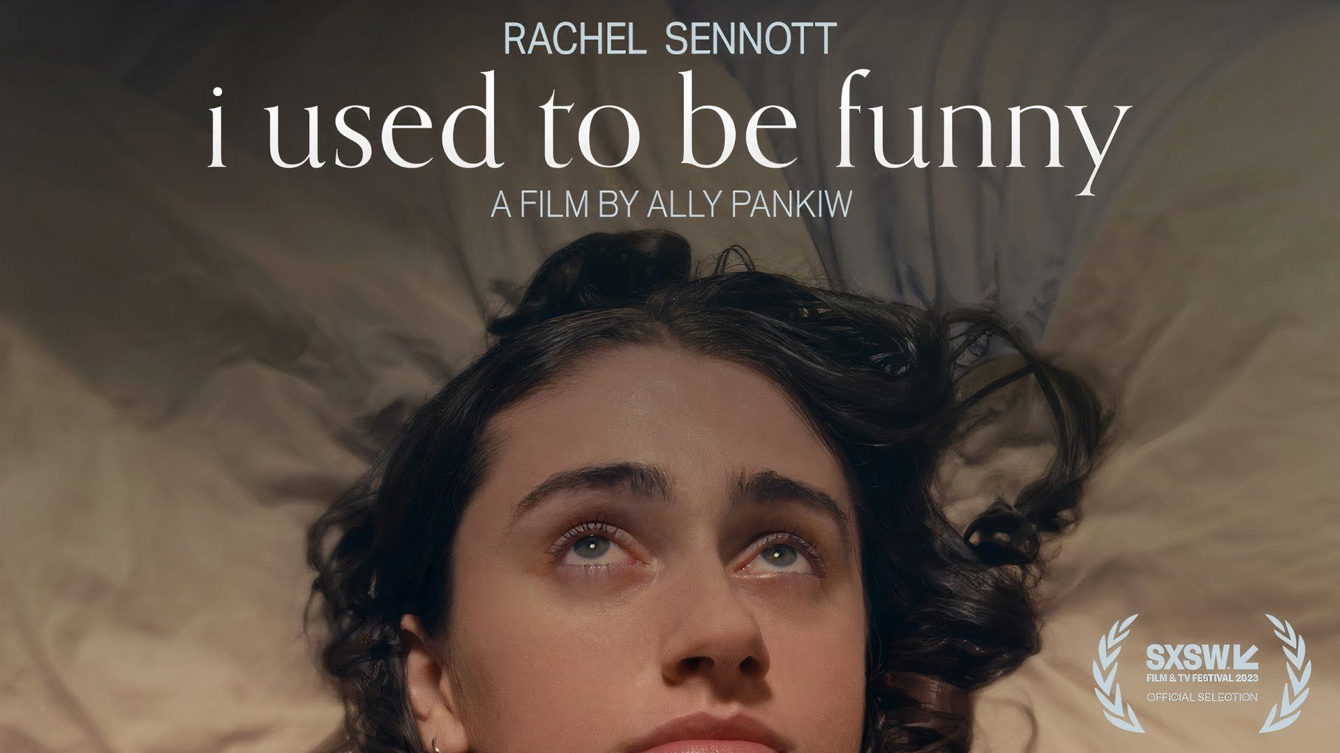Rachel Sennott lying in bed looking up at something off-screen in I Used to Be Funny