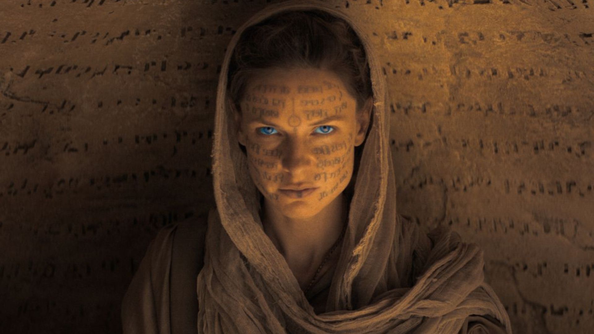 Rebecca Ferguson with markings on her face staring at the camera as Lady Jessica in Dune
