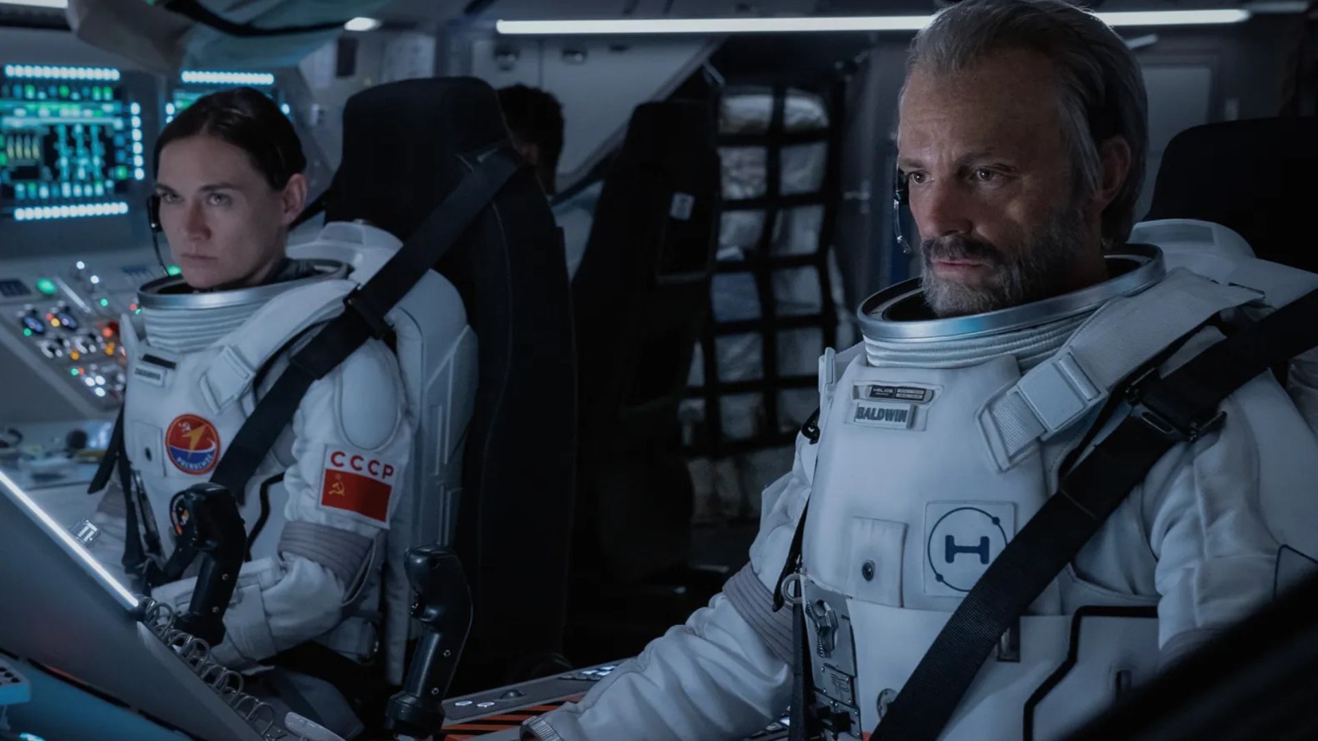 Shantel VanSanten and Joel Kinnaman both wearing spacesuits while in a spacecraft in For All Mankind