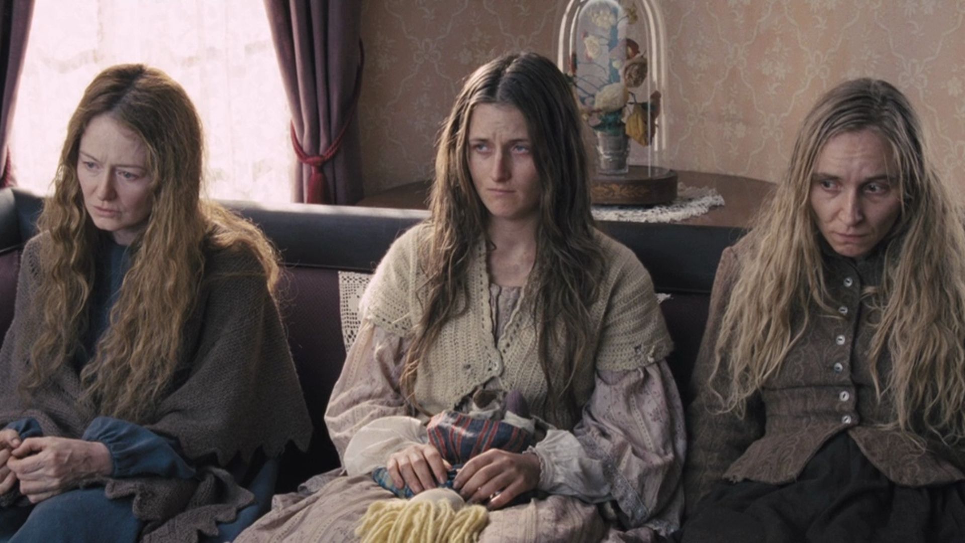 The immigrant women sit on a sofa in The Homesman