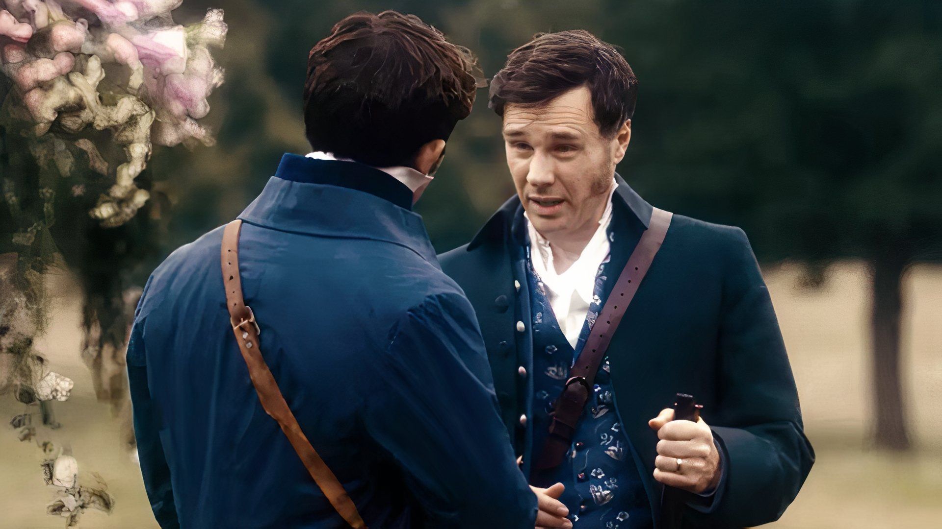 Viscount Bridgerton wearing a navy coat speaking in a courtyard to another man