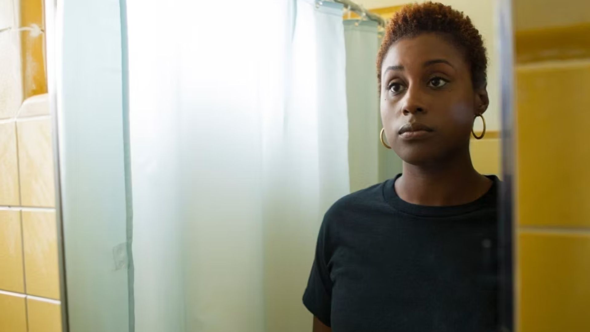 Issa Rae, staring blankly at herself in the mirror, in Insecure